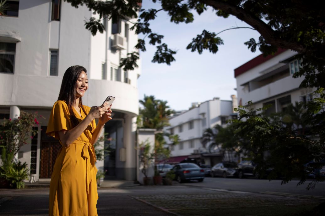A woman walking in the city with its smartphone. Image by freepik